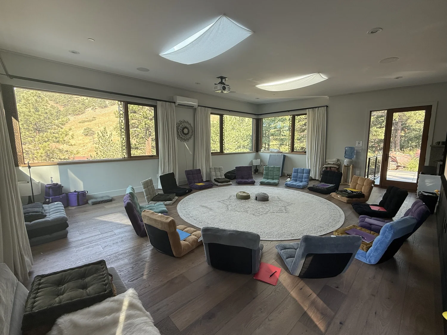 The now.haus studio with floor seating arranged in a circle and windows overlooking trees